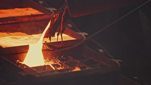 Streams of Hot Metal Fill Molds at Factory Stock Footage Beautiful Molten Metal Pours Into Molds