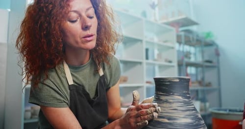 Woman Shaping Clay into Vase on Potter's Wheel