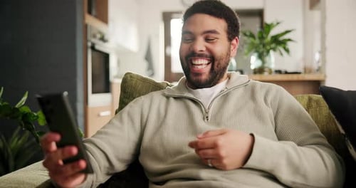 Home, funny and man on a couch, cellphone or typing with social media or connection in a lounge