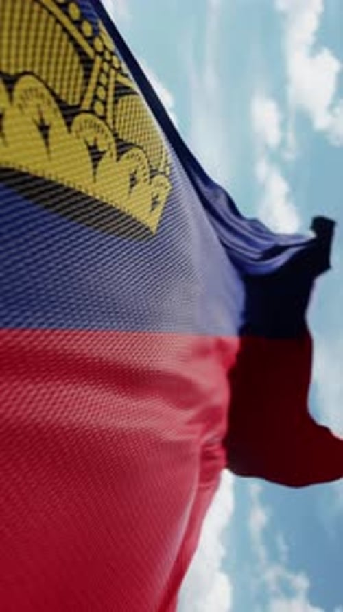 Realistic Liechtenstein Flag Waving Against Blue Sky