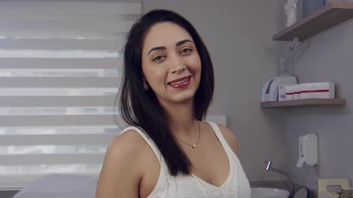 Young Hispanic woman in a doctor's office smiles