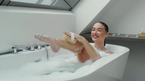 Woman bathing using body brush for beauty treatment
