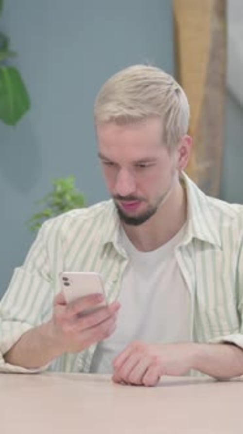 Man Reacting Negatively to Something on His Phone