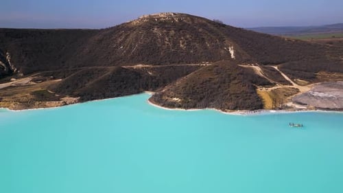 A Turquoise Tailings Pond Near a Cement Factory Surrounded By Rugged Hills The Vivid Water Contrasts