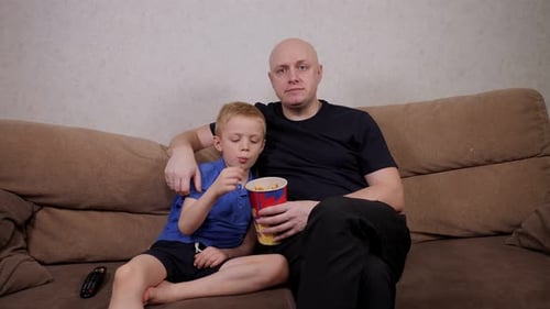 Father and Son Relaxing at Home Watching TV