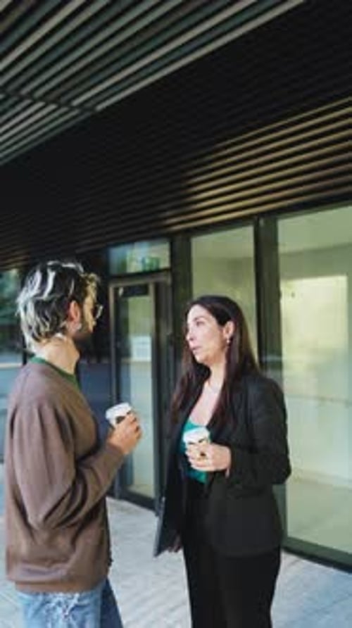Vertical video of a adult business people talking together outside of a corporate building