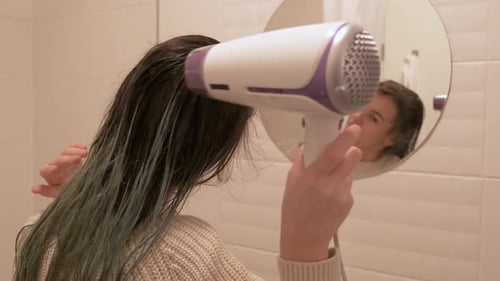 Young Adult Blow Drying Her Wet Hair
