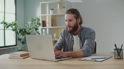 Man Works at Laptop in Bright Office