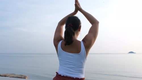 Woman Practicing Yoga on a Tropical Beach
