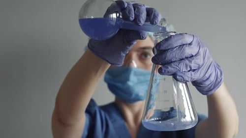 Scientist working in laboratory, processing of the laboratory sample in an Erlenmeyer flask.