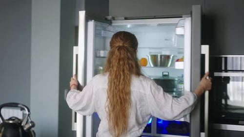 Young Woman Gets Fruits from Refrigerator