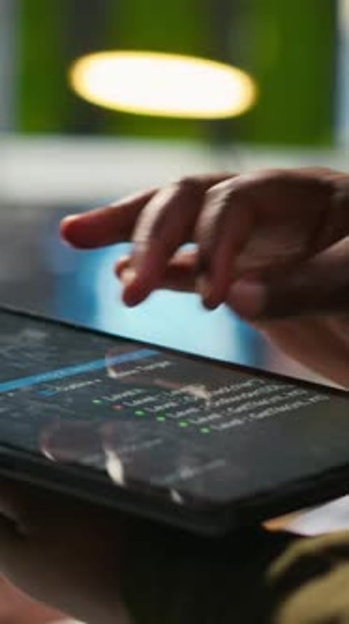 Vertikale Video-Nahaufnahme eines Ingenieurs, der ein Tablet zum Schreiben von Code verwendet, um die API für maschinelles Lernen zu entwickeln