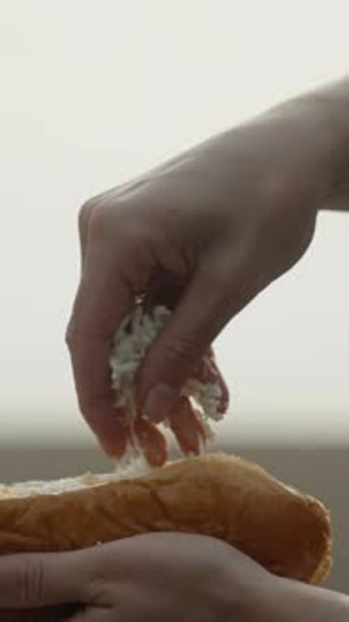 We cook hot dogs on the beach. sprinkle grated cheese bun on top. Vertical video Social Media