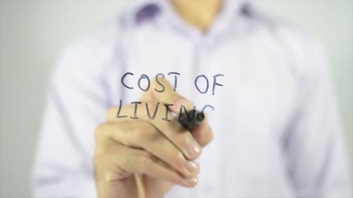 Writing Cost of Living Concept on Glass