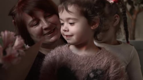 Back View of Girl is Hiding White Flowers Behind Her Back for Grandmother