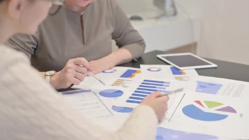 Adults Reviewing Charts and Graphs in Office