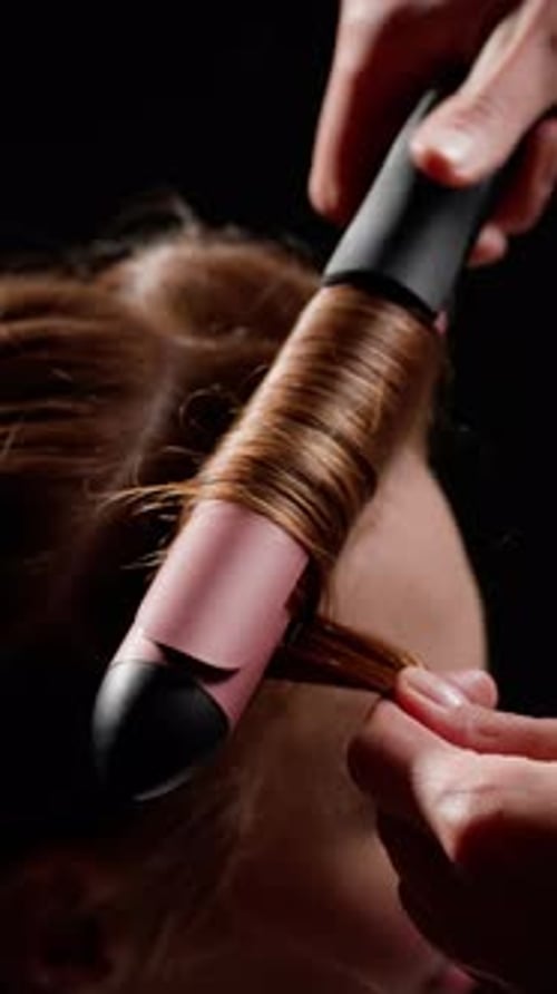 Nahaufnahme von Lockenstab, der Haare frisiert