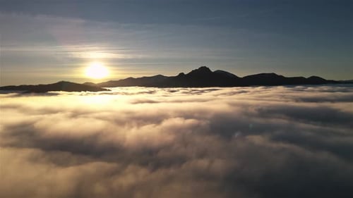 Fly Above Foggy Clouds in Mountain Landscape at Sunrise