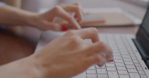 Hands Typing on Laptop Keyboard in Office