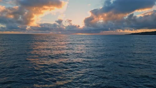 Ciel nuageux du soir, eau de l'océan ondulant au Ralenti, mer infinie au coucher du soleil