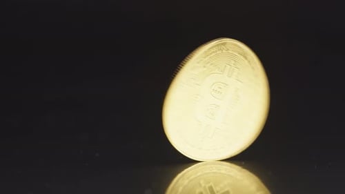 Golden Bitcoin Spins on Reflective Black Surface