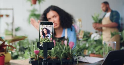 Mujer sonriente bloguera de redes sociales, diseñadora, florista grabando un nuevo video en un teléfono inteligente, hablando