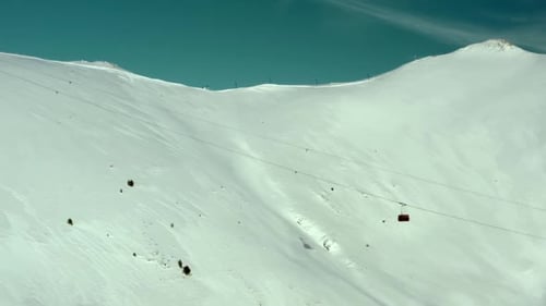 Thrilling Descent Skiers Conquer Massive Snowy Mountain Slope on a Sunny Day