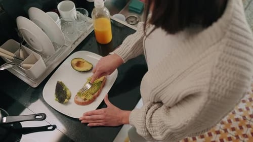 Adult Preparing Avocado Toast in Modern Kitchen