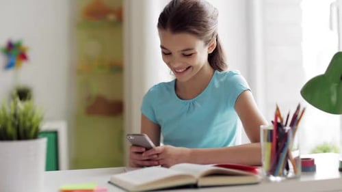 Girl Smiling Using Smartphone at Desk