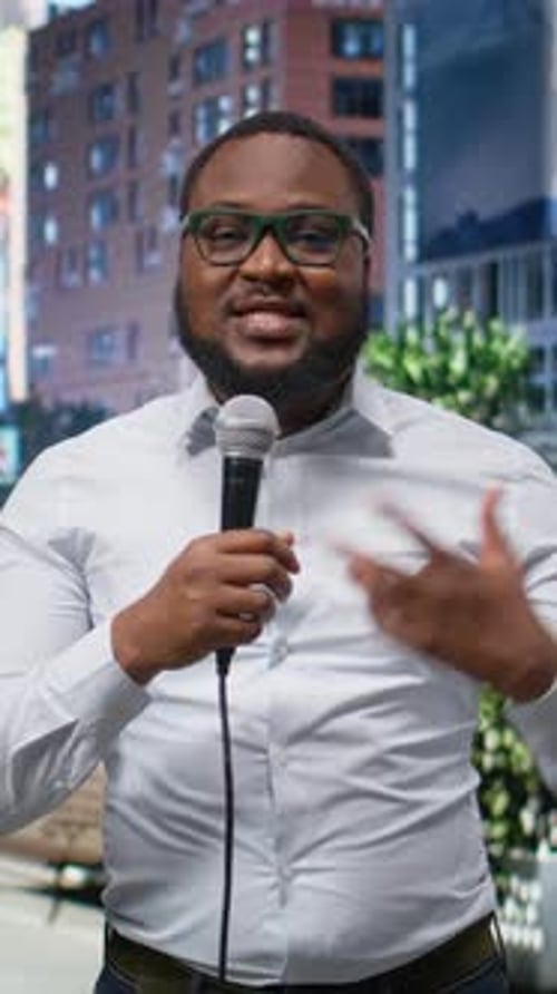 Vertical Video Black Journalist Talking on Air with a Microphone in Hand Doing Field Work