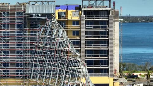 Aerial View of Ruined By Hurricane Ian Construction Scaffolding on High Apartment Building Site in