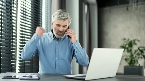 Angry Man Arguing on Phone in Modern Office