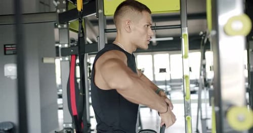 Man bodybuilder has workout at gym and exercising with cable crossover machine