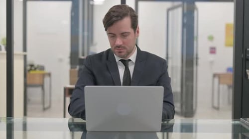Man Working on Laptop in Modern Office