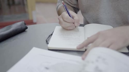 A male student taking notes by hand