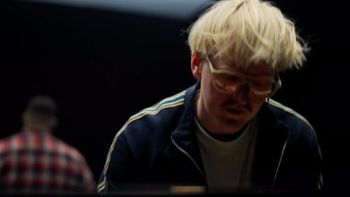 A Musician Smiling While Playing The Piano