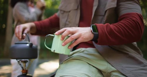 Couple, outdoor and camping in forest with coffee, fresh air and sunshine on holiday away
