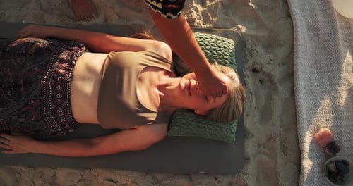 Woman Receives Crystal Healing on a Sandy Beach