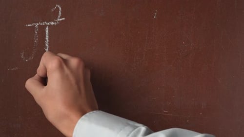 Textured Brown Chalkboard Background Male Hand Writing a Formula Equation on the Board with a Piece