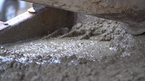 Una mezcla de concreto líquido se vertió en un encofrado en una obra de construcción. Cámara lenta de primer plano portátil
sh