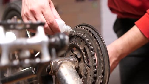 Closeup Shot of Lubricating a Dirty Old Bicycle Chain