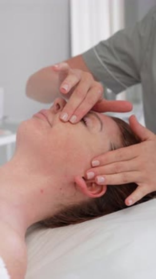 Woman Relaxing with Facial Massage at Day Spa