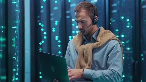 Experienced Professional IT Specialist Equipped with Laptop Working in a Modern Data Center