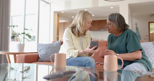 Two Women Chatting and Laughing Together at Home