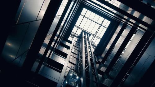 Bottom-up view of interior of a modern office. Black walls, elevator, panoramic roof