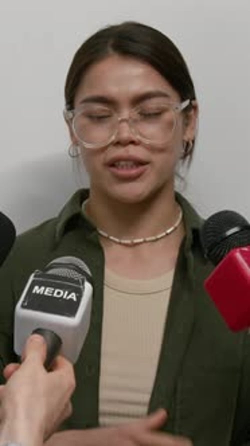Woman Giving Interview to Multiple Unrecognizable Reporters