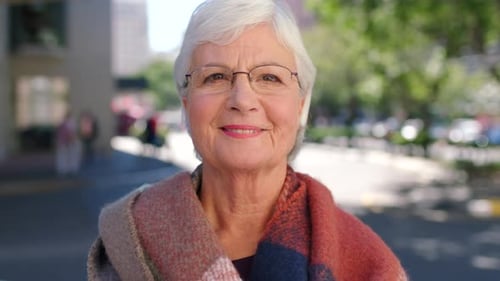 Portrait of a laughing older woman looking happy outside in an urban street