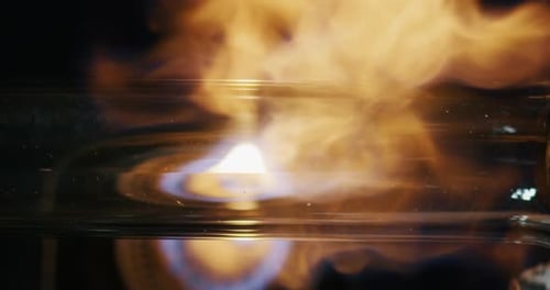 Slow motion of experienced glass blower working with flame on a handmade art piece of glass from p