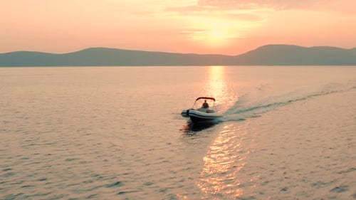 Boat Moves Across Water at Sunset