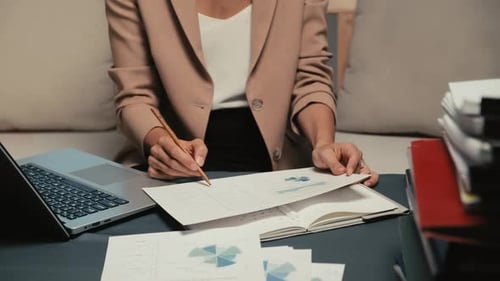 Female Worker Revising Financial Document at Office